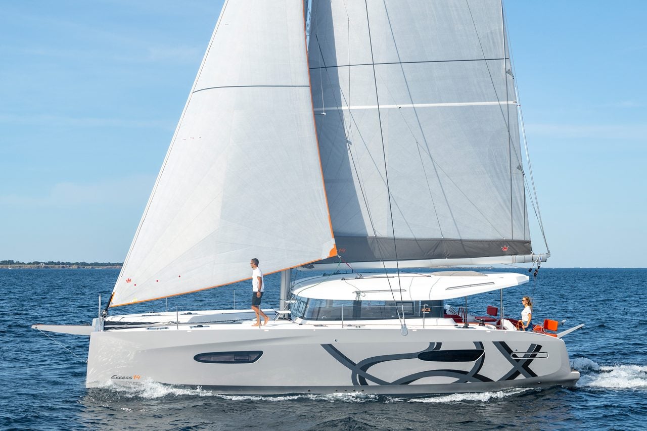 Excess 14 catamaran sailboat sailing with man on deck