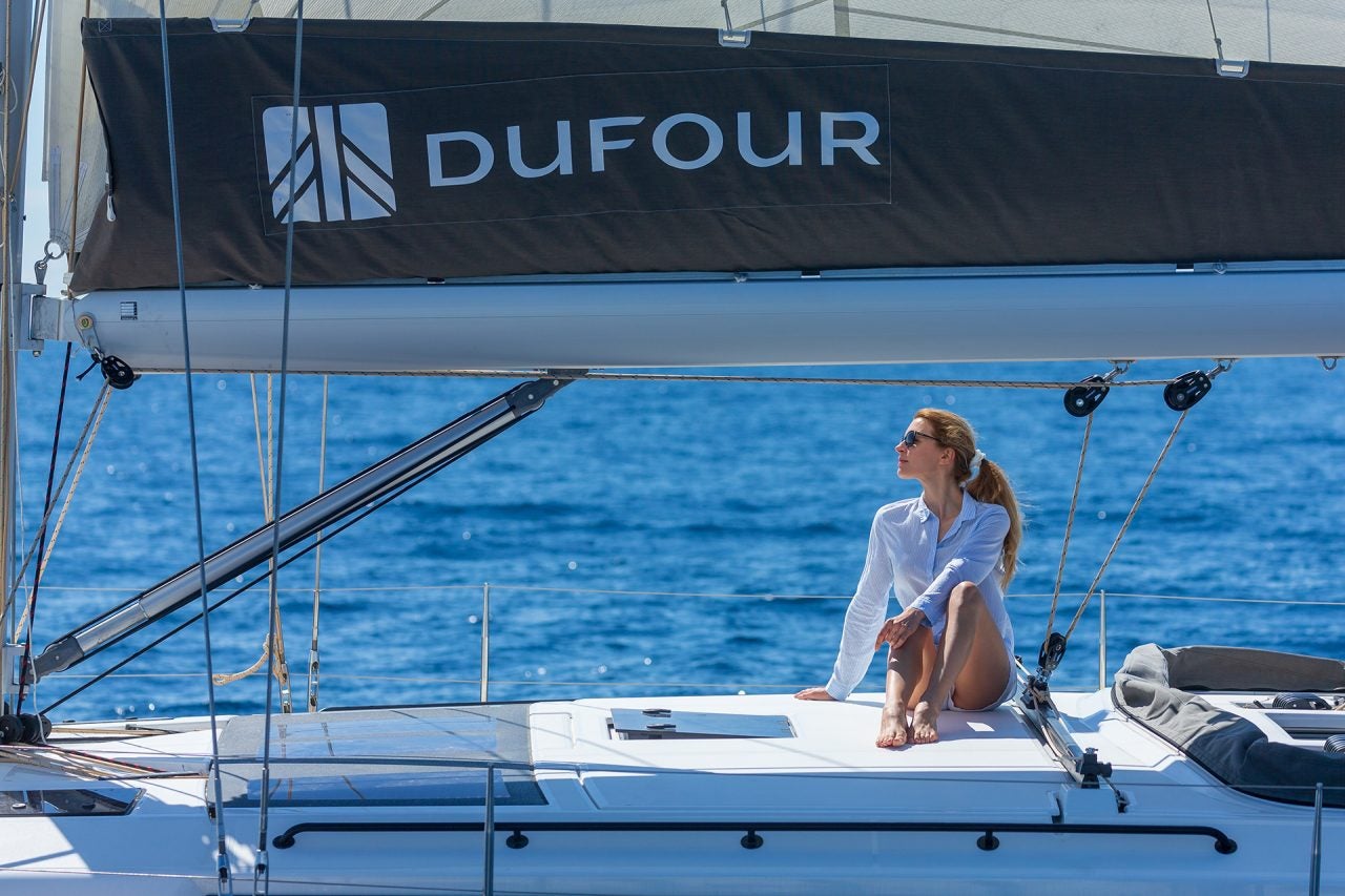 Woman relaxing on deck of Dufour 530 monohull