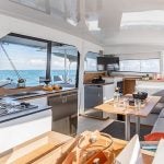 Dining table setting with waterfront view sailing catamaran Bali 4.4