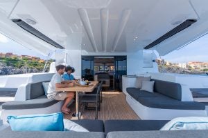 Couple sitting at cockpit table of Lagoon 51 sailing catamaran