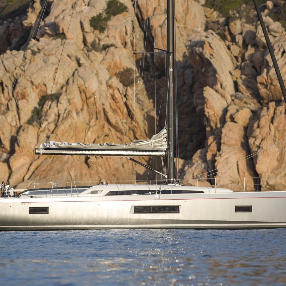 Beneteau Oceanis 46.1 monohull at anchor with rugged cliff backdrop