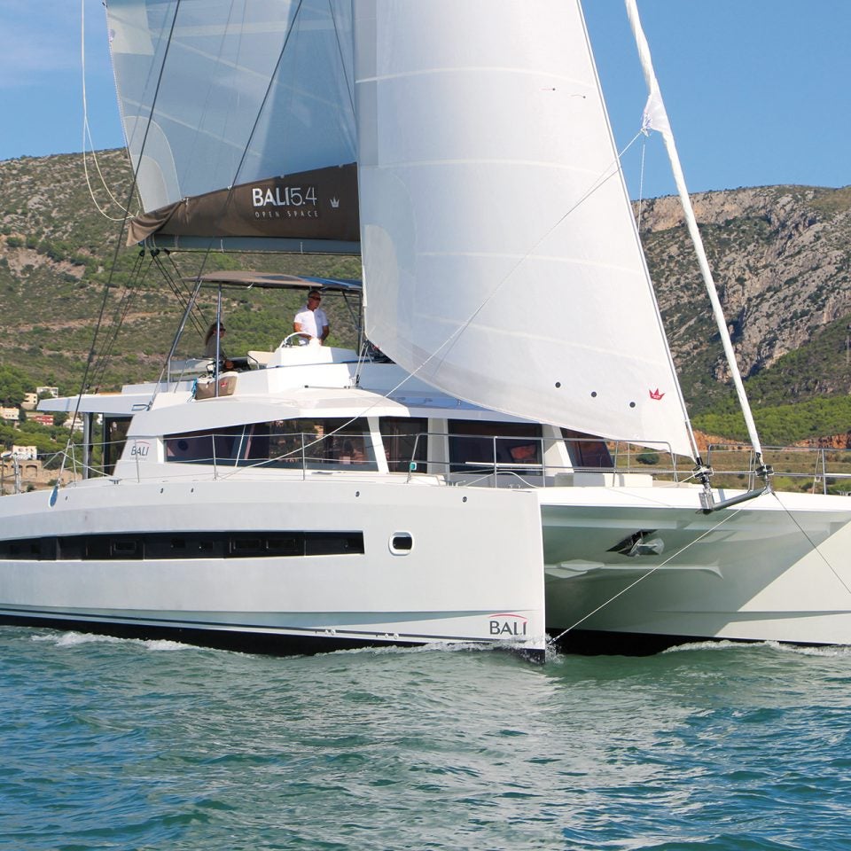 Bali 5.4 luxury catamaran sailing on blue waters with mountain backdrop