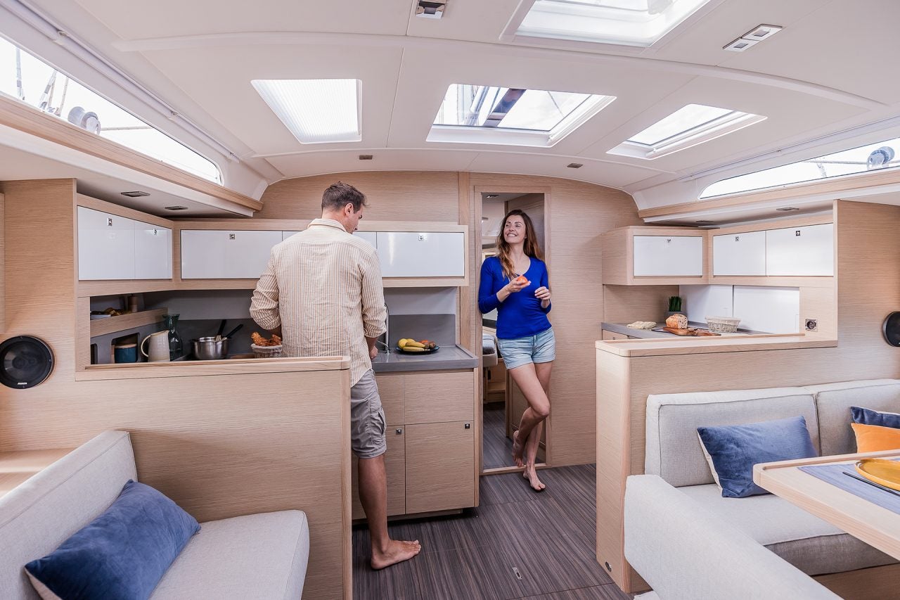 Couple using Dufour 470 electric sailing monohull kitchen galley