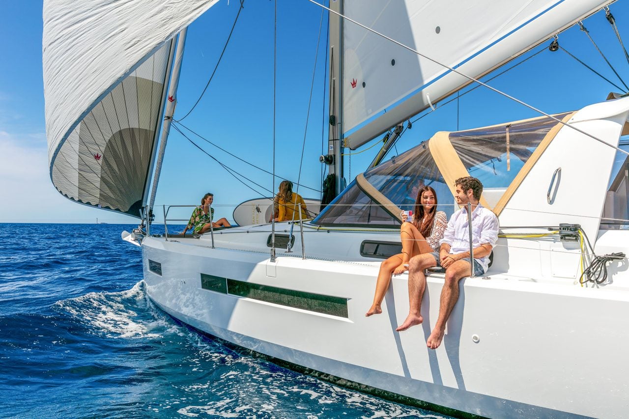 Couple seated on side deck of the Sun Loft 47 sailboat