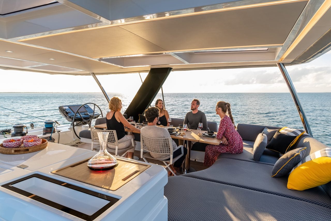 Group of people at dining table of the Lagoon 65 catamaran