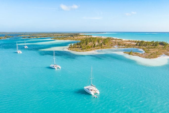 View of line of islands with three Dream Yacht catamarans in blue waters