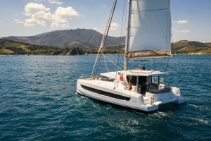 Bali 4.2 catamaran at sail with backdrop of lush green mountains