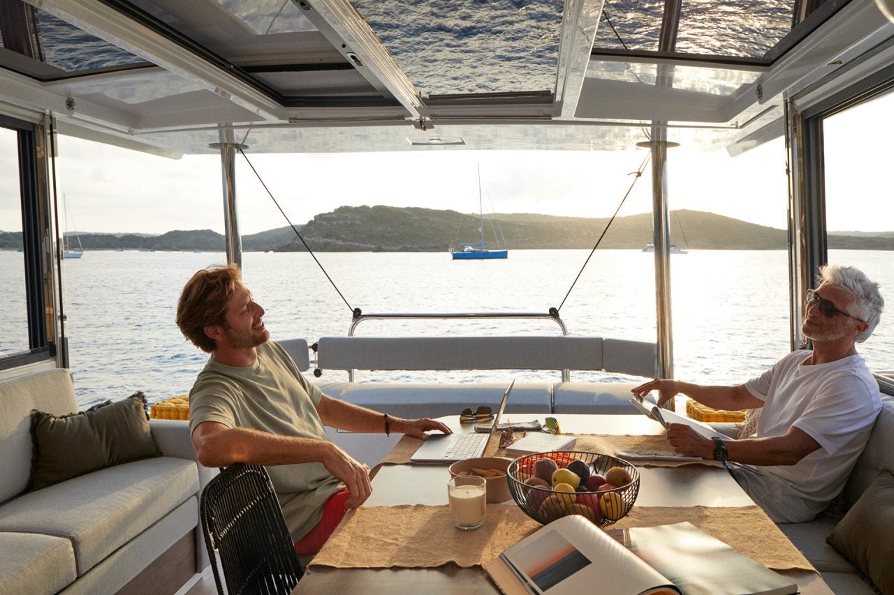 Two men sitting at the interior dining table of the Bali 4.4