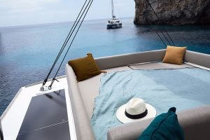 Bali 4.8 catamaran flybridge sunbeds with sea and rugged coast views