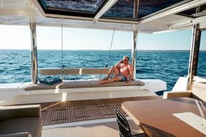 Man sitting on transom bench seating on the Bali 5.4 sailing catamaran overlooking sea