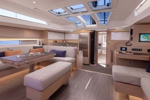 Dufour 61 yacht saloon and dining area with large overhead skylights