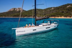 Dufour 61 sailing mono at anchor in bright blue waters