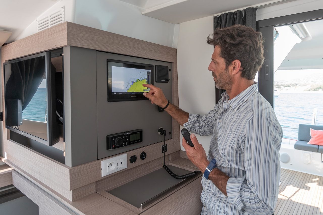 Man using interior electronics on the Isla 40 sailing catamaran