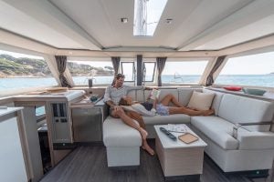 Couple seated in salon of the Fountaine Pajot  67 catamaran