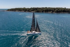 Sun Odyssey 350 sailing monohull at sail near coast