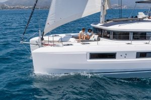 Lagoon 51 luxury catamaran sailing with couple on front deck