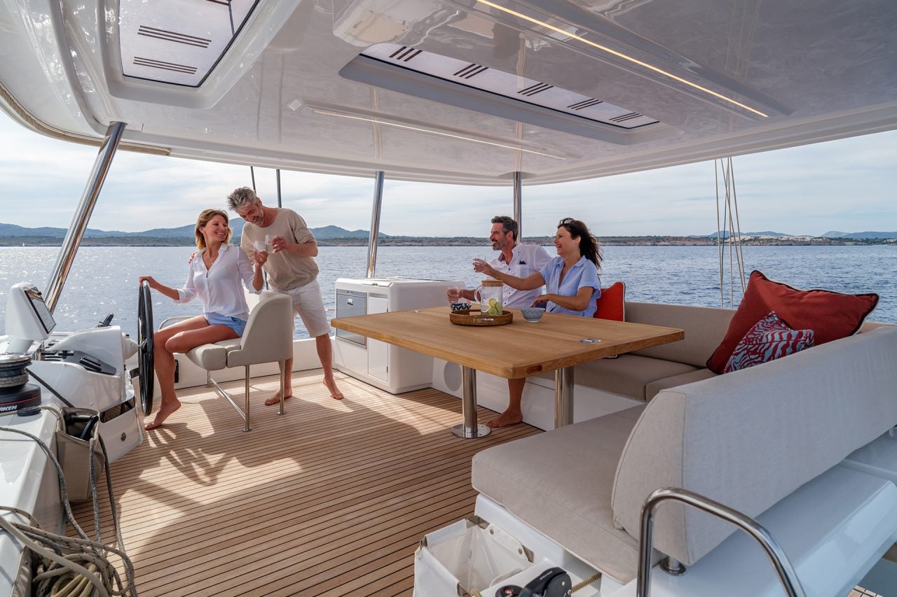 Friends enjoying the expansive Lagoon 55 sailing catamaran flybridge