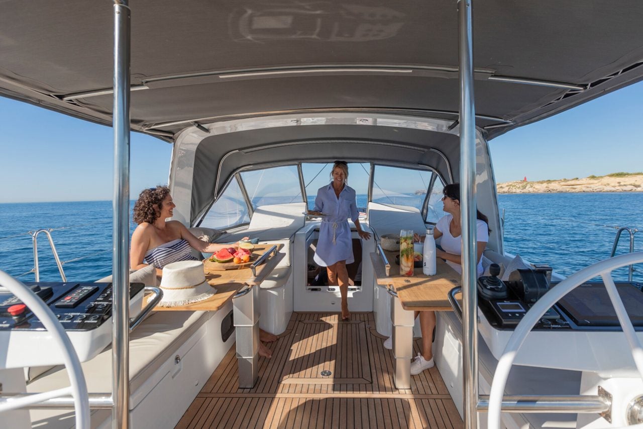 People at cockpit dinging table of the Beneteau Yacht 54 luxury monohull